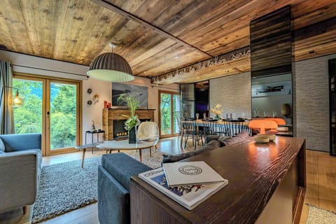 Relax in this cozy Megève living room with alpine views, warm wood tones, and mountain charm—perfect for après-ski evenings or summer afternoons in the heart of the French Alps.