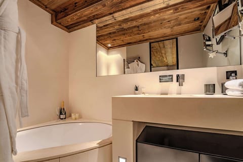 Elegant bathroom with natural stone textures and soft light—unwind in Megève’s peaceful luxury, perfect after a snowy ski day or a summer hike in the surrounding mountains.