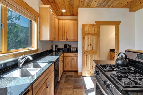 The well equipped kitchen has stainless appliances, black granite counters, and wood cabinets.