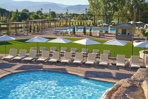 Lounge under crisp umbrellas while mountains frame your day.