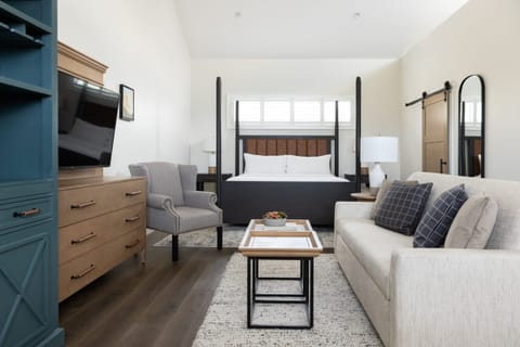 Unwind in a sunlit suite with plush bed and sofa.