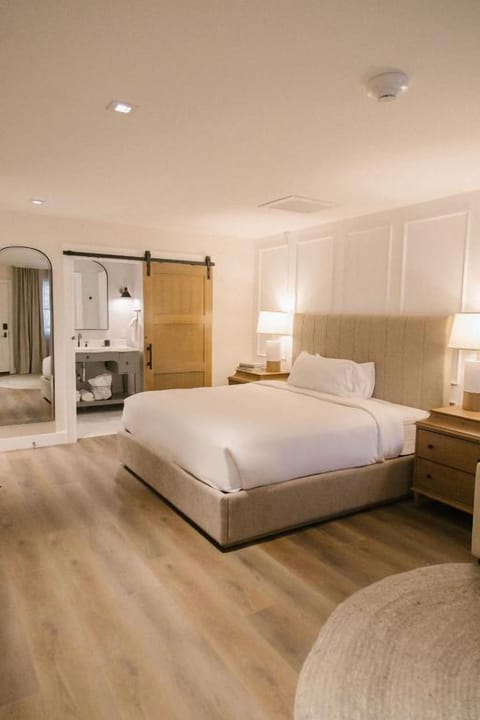 Drift off in a serene king bed with warm lighting.