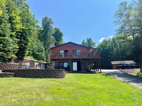 Lake front of house and large patio with fire pit and seating for 10