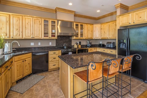 Spacious kitchen with an island and bar seating for three people | Main Level