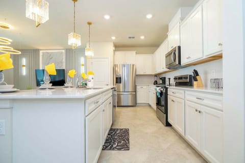 This fully equipped gourmet kitchen features sleek stainless appliances, spacious counters, and elegant pendant lighting-perfect for home-cooked meals.