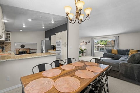 Open-concept comfort at its best! . From group dinners at the farmhouse-style table to lounging in the sunny living room, this airy space is made for connection, conversation, and cozy nights in.