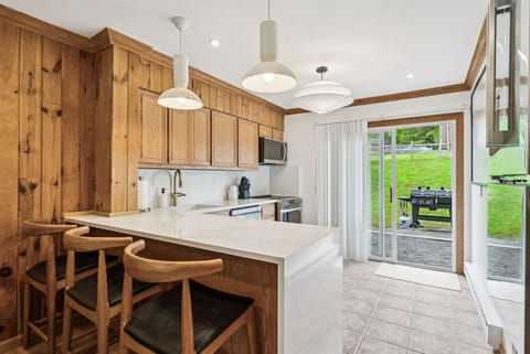 The open kitchen features a breakfast bar, sleek quartz counters and modern LG appliances