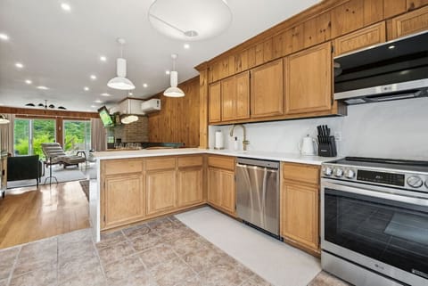 The open kitchen features a breakfast bar, sleek quartz counters and modern LG appliances