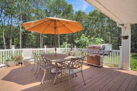 Rear deck with dining table for six and gas grill overlooking fenced yard
