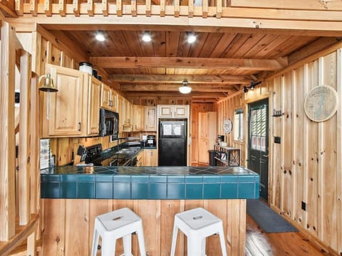 The chalet kitchen is the heart of the home, combining rustic charm with modern convenience. Rich wooden cabinets, their surfaces weathered to perfection, line the walls, offering plenty of storage and a touch of timeless elegance. The countertops are per