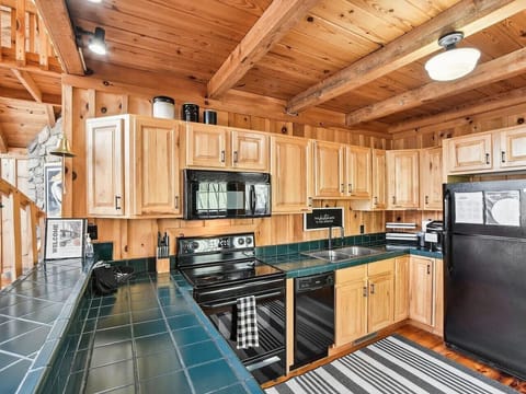 The chalet kitchen is the heart of the home, combining rustic charm with modern convenience. Rich wooden cabinets, their surfaces weathered to perfection, line the walls, offering plenty of storage and a touch of timeless elegance. The countertops are per