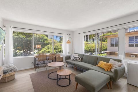 Stylishly decorated Waikiki one-bedroom retreat featuring modern furnishings, cozy textures, and bright, airy windows overlooking lush island scenery.