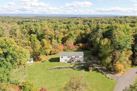 Bird’s-eye view of the home with spacious green surroundings