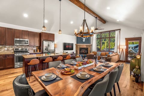 Spacious great room with dining area, bar, seating, kitchen, and fireplace.