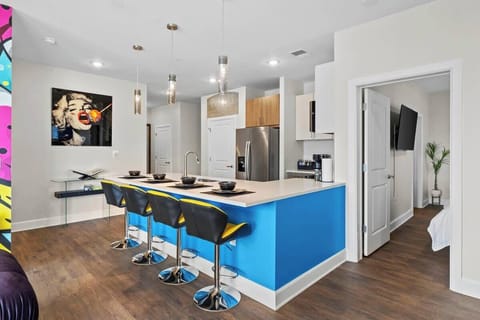- Sleek open kitchen with bright blue island  
- Modern appliances perfect for cooking  
- Bar seating ideal for group travel  
