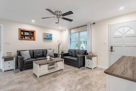 Living room with comfortable sofas, ceiling fan, coffee table and smart tv