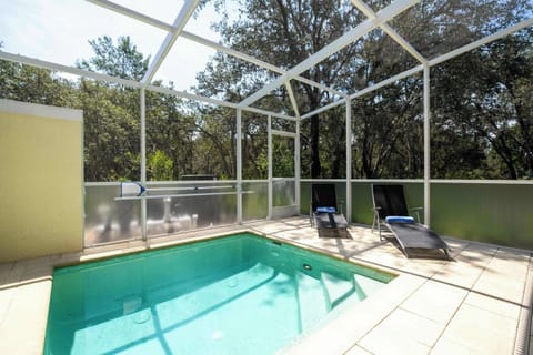 Unwind in your private screened pool oasis framed by lush oak trees – complete with two comfy loungers for ultimate relaxation!