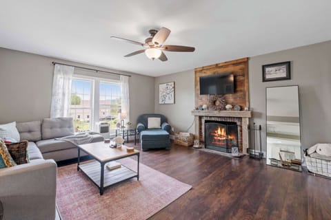 Gather 'round the fire after a day of lake fun—this warm and inviting living room offers plush seating, a smart TV, and that perfect touch of rustic charm with its wooden mantel and glowing hearth.