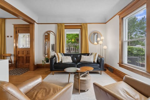 Settle into this thoughtfully designed living space where natural light streams through large windows, highlighting warm wood details and comfortable seating perfect for relaxing.