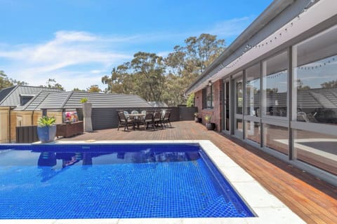 An outdoor seating area beside the pool is perfect for dining alfresco during summer.
