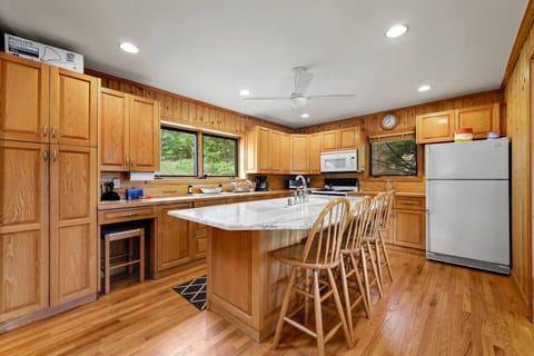 Fully equipped kitchen with warm wood cabinetry, center island, and breakfast bar seating.