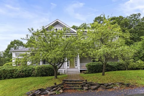 Grand front view of the home framed by mature trees.