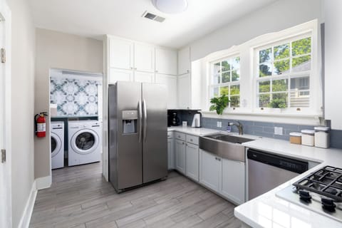 Walk into a clean, fully equipped kitchen with laundry room just beyond