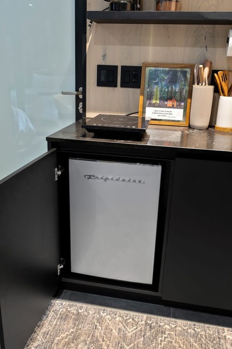 Compact yet fully equipped—cook up simple meals with a portable stovetop and keep your favorites fresh in the retro-style mini fridge.