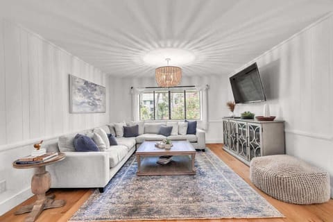 Bright living room with a large sectional sofa and a mounted flat-screen television