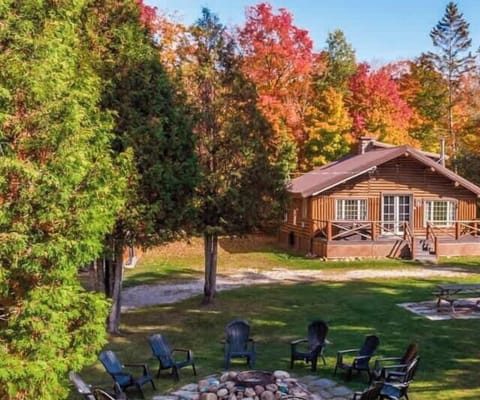The charming exterior of the cabin, nestled among trees and greenery.