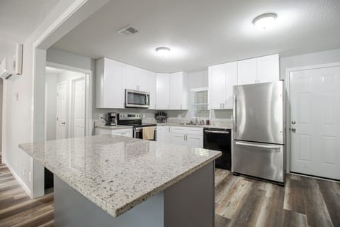 Experience modern coastal living in this bright kitchen, featuring stainless steel appliances and ample counter space for culinary creations.