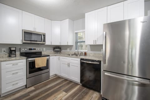 This inviting kitchen boasts sleek cabinetry and modern appliances, perfect for family meals and entertaining during your beach getaway.