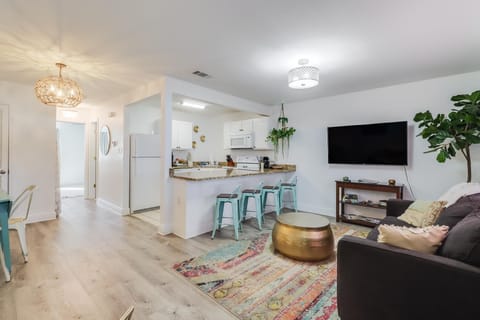 Step into this cozy living space featuring an open layout with stylish décor, a smart TV, and easy access to the full kitchen.
