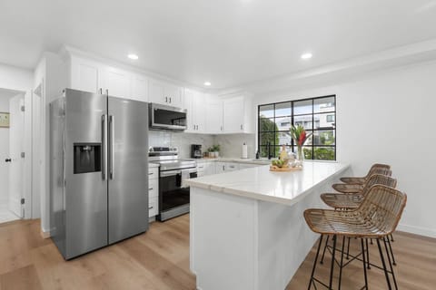 This airy kitchen features quartz counters, stainless steel appliances, and rattan bar seating—perfect for group breakfasts or evening cocktails. A modern coastal Crown Point Airbnb just a short walk to San Diego’s scenic bayfront.