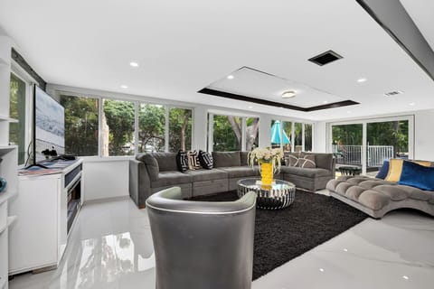 Spacious living room with wraparound sofa and lush outdoor views.