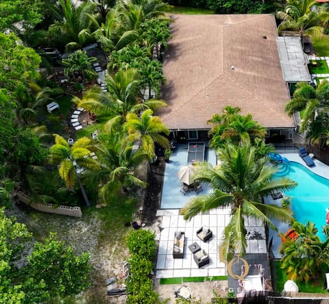 Front of home tucked in lush greenery with spacious layout.