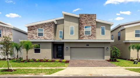 Modern two-story home with a spacious driveway and lush landscaping