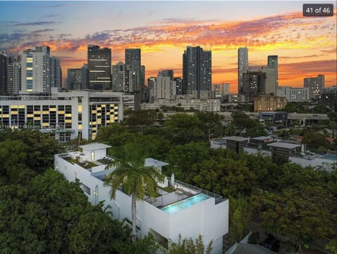 Stunning sunset cityscape view of high-rise buildings from a rooftop terrace.