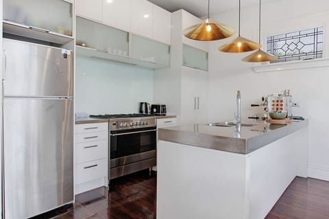 The kitchen is well-equipped with a coffee machine, dishwasher, microwave, gas cooktop, oven, and fridge/freezer.