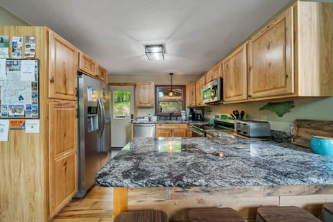 Kitchen Features Granite Countertop and Bar Seating