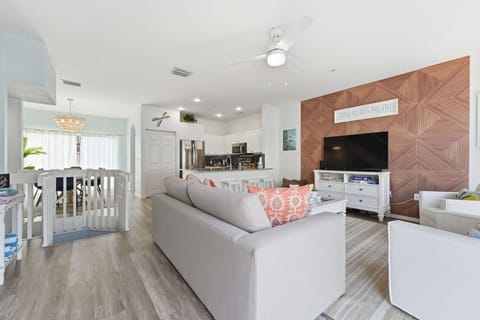 Open-concept living area with beachy tones, stylish décor, and a cozy seating setup. Enjoy the inviting flow from living room to kitchen and dining, all filled with natural light—perfect for gatherings and relaxed coastal living.
