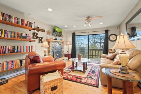 Spacious den with comfy leather seating, gas logs, SmartTV, & extensive library