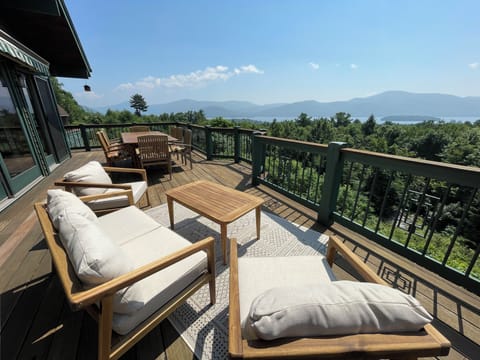 Main level deck with eight person dining table and seating area