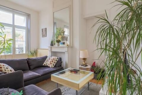 Salon avec canapé et fauteuil, accès à la terrasse, télévision