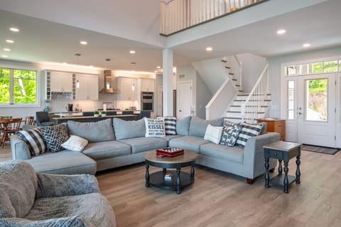 Spacious open-concept layout featuring a modern kitchen, large sectional, and bright natural light—ideal for group gatherings. 🍽️🌞👨‍👩‍👧‍👦