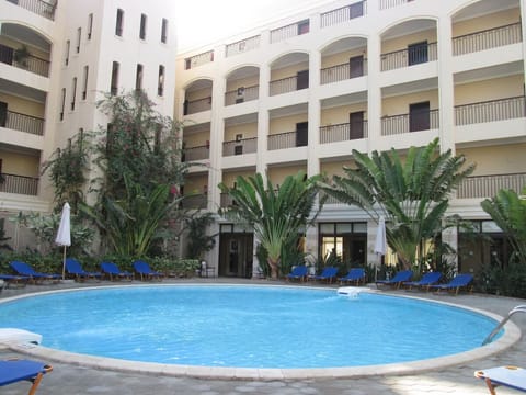 Unwind poolside beneath palms in a serene courtyard oasis.