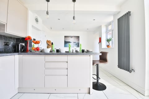 A modern, fully fitted kitchen with breakfast bar