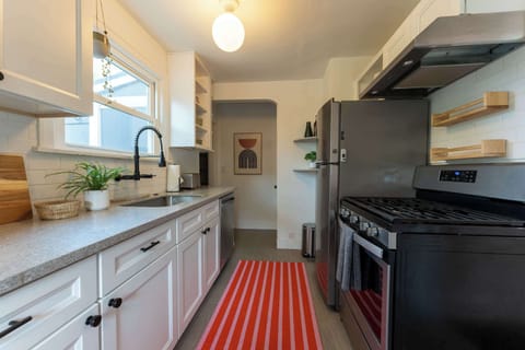 Freshly updated kitchen with open shelving, stylish tile, and chef-ready amenities.