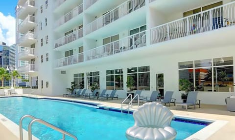  Our pool is surrounded by tall glass buildings and lounge chairs.