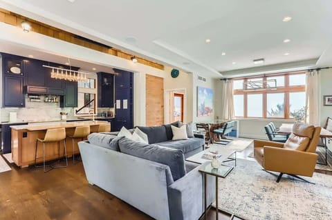 Spacious open layout featuring kitchen, living area, and two dining tables for versatile use